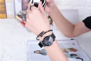 Close-up of minimalist black watch with matching nail-shaped ring and bracelet set