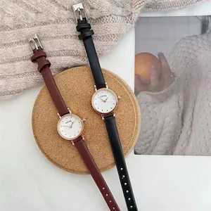 Detail of vintage women's quartz watches with slim leather straps in black and brown