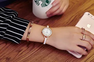 Montre à quartz élégante en or rose pour femme avec bracelet en cuir blanc au poignet