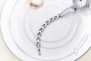 Close-up of a silver fashion watch with diamond bezel and stylish hollow chain strap