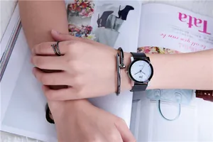 Minimalist black leather watch paired with nail-style bangle and matching ring set