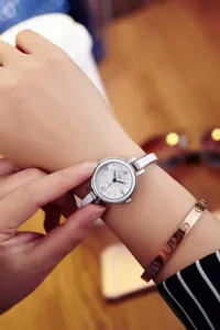 Gros plan d'une montre à quartz pour femme avec bracelet en cuir blanc et boîtier argenté
