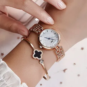 Ensemble montre femme or rose et bracelet trèfle noir porté sur le poignet
