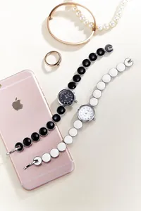 Detaillierte Makroansicht stilvoller Damen-Emaille-Armbanduhren in Schwarz und Weiß Optik