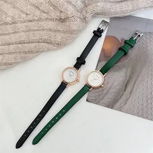 Close-up of elegant ladies' wristwatches with green and black leather straps and sunray dials