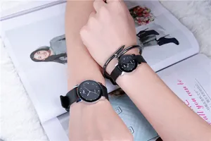 Matching couple watches with black minimalist dials and nail-shaped metal bracelet