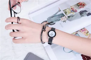 Detail of minimalist JW watch with industrial nail-style metal bracelet and ring set