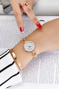 Close-up of gold quartz watch set with heart link band, screw bangle and nail ring