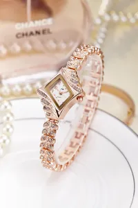 Close-up of rose gold watch with leaf-shaped rhinestone band and diamond-cut dial