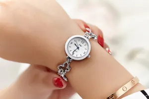 Detail of silver quartz watch with butterfly bracelet band on woman's wrist