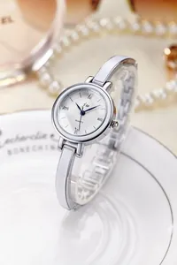 Détail du cadran texturé blanc avec aiguilles bleues sur montre quartz en argent