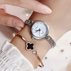 Elegant silver round quartz watch for women paired with a clover bracelet on wrist
