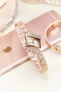 Macro detail of rose gold watch with leaf-shaped rhinestone strap and diamond dial