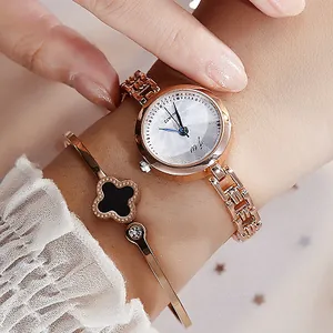 Elegant rose gold women's watch with matching black clover bracelet on wrist