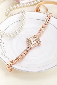 Detail of rose gold square watch featuring rhinestone-set wheat-patterned mesh bracelet