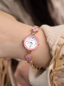 Dettaglio orologio da donna al quarzo dorato con fiori in smalto rosa e strass