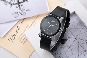 Minimalist quartz watch detail with black dial, silver markers and leather strap