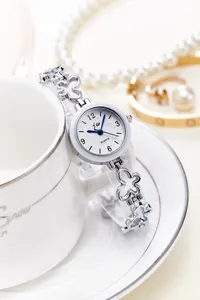 Detail of silver women's watch with four-leaf clover bracelet links on a white background