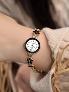 Dettaglio dell'orologio al quarzo oro rosa con cinturino a fiori neri al polso