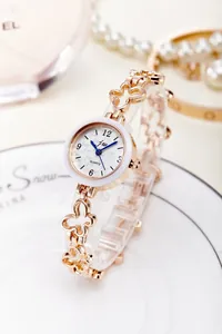 Detail of rose gold butterfly bracelet watch with blue hands and white dial