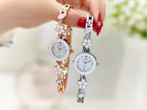 Dettaglio del cinturino floreale con petali bianchi e cristalli su orologio al quarzo