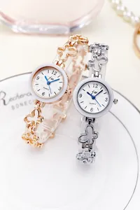 Close-up of rose gold and silver quartz watches with butterfly-shaped metal chain bands