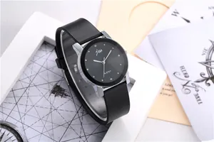Detail of JCV A-5707 quartz watch featuring a black dial and silver case on a stylish desk