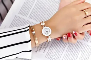 Primo piano dell'orologio floreale oro rosa con bracciale a vite e anello a cuore