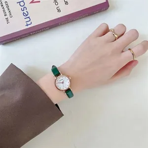 Close-up of elegant retro ladies' watch with a thin green leather strap and gold case