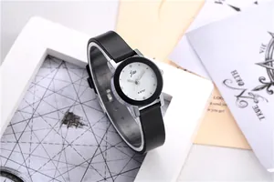 Close-up of minimalist fashion watch with crystal indices and a black leather strap