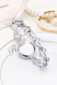 Detailed view of silver fashion watch with hollow clover-shaped bracelet strap