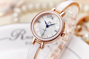 Détail d'une montre à quartz or rose avec cadran texturé et bracelet en émail blanc
