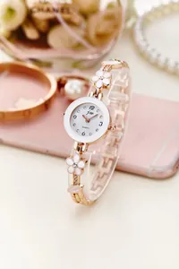 Dettaglio del cinturino in oro rosa con maglie a fiori bianchi e piccoli cristalli