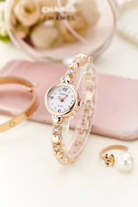 Detail of rose gold quartz watch featuring heart-shaped links and crystal accents
