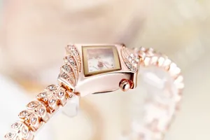 Detailed view of rose gold quartz watch featuring diamond-set case and leaf-shaped bracelet