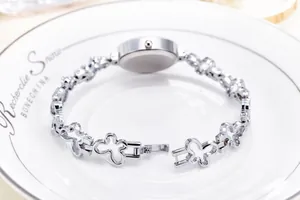 Close-up of silver hollow butterfly link strap and folding clasp on women's quartz watch