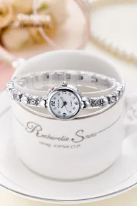 Detail of silver ladies quartz watch featuring a crystal heart bracelet and white dial