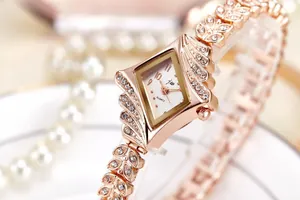 Close-up of rose gold quartz watch with diamond accents and leaf-shaped bracelet band