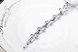 Detail of silver ladies watch featuring butterfly-shaped cut-out metal link strap