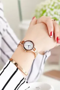 Close-up of elegant rose gold women watch and screw motif bangle on a model wrist