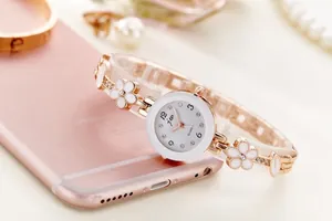 Dettaglio del cinturino in oro rosa con fiori bianchi e brillanti accenti di cristallo