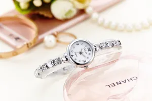 Detail of silver ladies watch featuring heart-shaped hollow metal strap with rhinestones