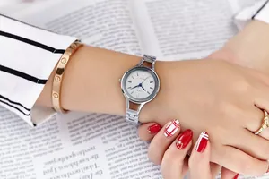 Close-up of GEDI silver quartz watch paired with a rose gold bracelet and heart ring