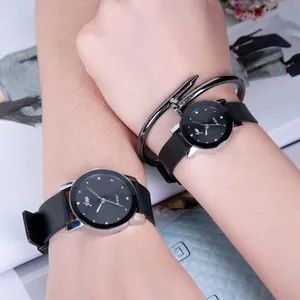 Minimalist black quartz watch with silver casing and crystal hour markers on wrist
