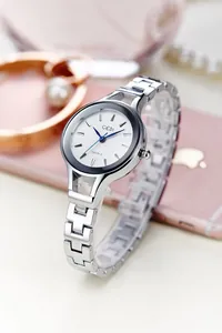 Detailed macro shot of GEDI silver metal watch band beside luxury lifestyle accessories