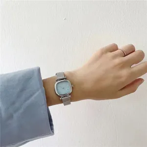 Gros plan d'une montre carrée bleu clair avec bracelet Milanais en acier inoxydable