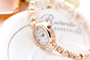 Close-up of rose gold bracelet watch featuring heart-shaped links and sparkling crystals