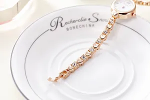 Detail of rose gold fashion watch featuring heart-shaped links and sparkling rhinestones