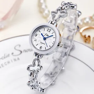 Women's silver quartz watch with butterfly hollow links on white ceramic plate