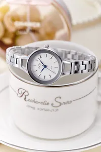 Macro shot of a stylish silver metal watch band on a white cup with luxury jewelry background